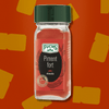Flacon de piment fort moulu Fuchs sur fond rouge, parfait pour ajouter une touche épicée et intense à vos plats